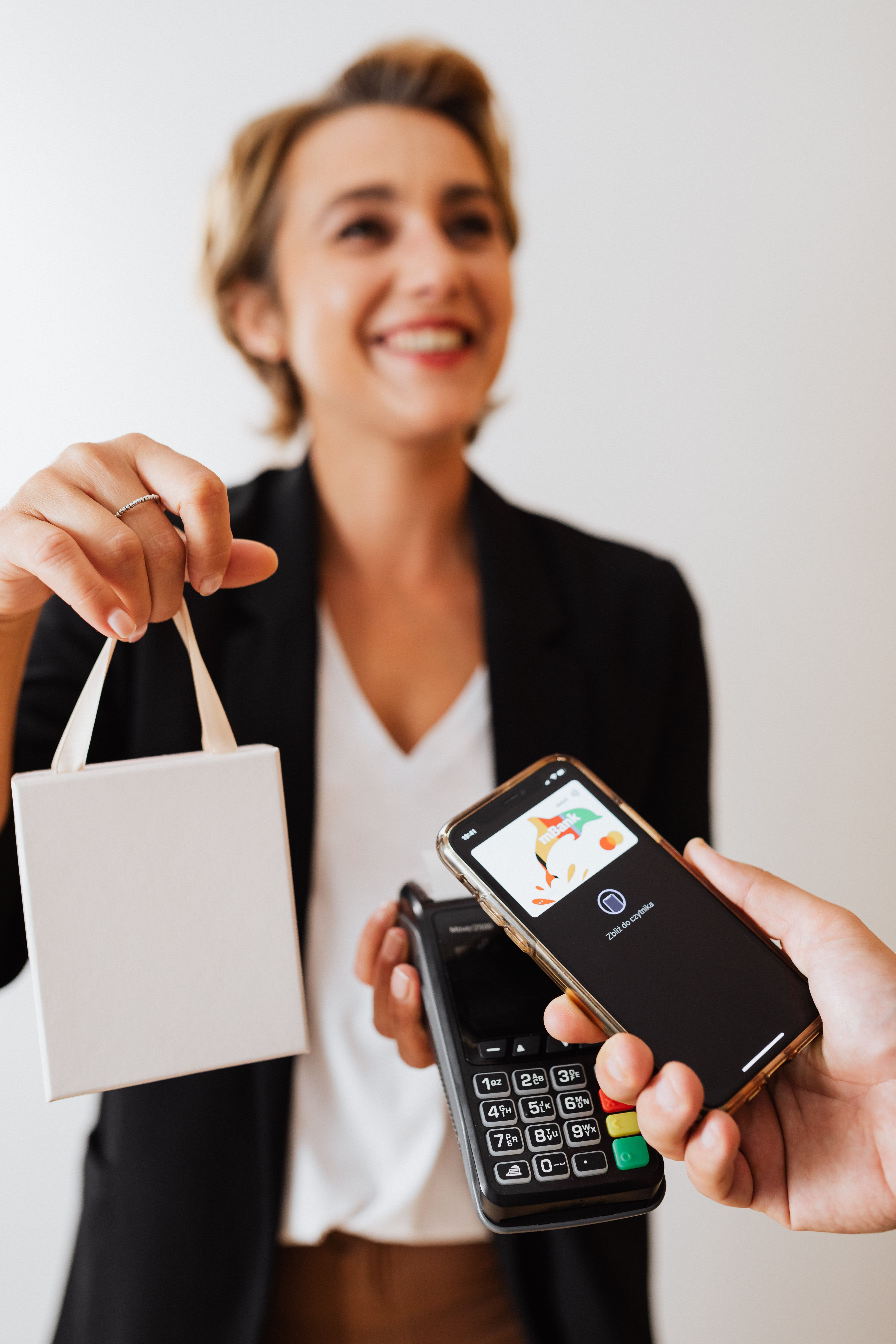 A shop owner taking a mobile tap-to-pay payment from a customer
